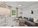 Cozy living room featuring a comfortable sofa, a large window overlooking a greenery, and tasteful decor at 628 Topsail Drive Pkwy, Villa Rica, GA 30180