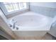 Bathroom featuring a corner jacuzzi tub under a window and tiled surround at 2003 Hubbard Ct, Villa Rica, GA 30180