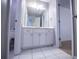 Well-lit bathroom features a single vanity with white cabinets and white tiled floors at 2003 Hubbard Ct, Villa Rica, GA 30180