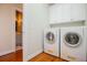Convenient laundry room with a washer and dryer set, storage cabinets, and hardwood floors at 2003 Hubbard Ct, Villa Rica, GA 30180