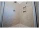 Shower stall featuring neutral tile, built in shelves, and glass door at 2003 Hubbard Ct, Villa Rica, GA 30180