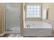 Bathroom view showcasing soaking tub, glass shower, and mosaic tile accent at 2385 Cape Courage Way, Suwanee, GA 30024