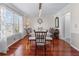 This dining room is spacious and bright, featuring hardwood floors, and glass table at 2385 Cape Courage Way, Suwanee, GA 30024