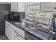 This kitchen features granite countertops, stainless steel sink and faucet with gooseneck at 2385 Cape Courage Way, Suwanee, GA 30024
