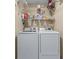 Modern laundry room with washer, dryer and wire shelving for storage at 2385 Cape Courage Way, Suwanee, GA 30024