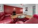 Bright living room featuring red accent wall, modern decor, and hardwood floors at 2385 Cape Courage Way, Suwanee, GA 30024