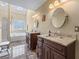 A main bathroom features dual vanities, soaking tub under a sky light, and a glass enclosed shower at 2385 Cape Courage Way, Suwanee, GA 30024