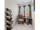 Cozy sitting area features a unique bookshelf, table, and accent chair with natural light at 2385 Cape Courage Way, Suwanee, GA 30024