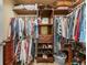 Well-organized walk-in closet with shelving and hanging storage for clothes and shoes at 2385 Cape Courage Way, Suwanee, GA 30024