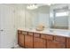 Bathroom vanity with double sinks, framed wood cabinets, large mirror and modern lighting at 2887 Goldfinch Cir, Marietta, GA 30066