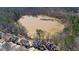 Aerial view shows the neighborhood homes bordering the lake and surrounded by mature trees at 325 Morning Mist Walk, Suwanee, GA 30024