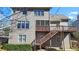 Exterior view of the home showcases a private back deck with stairs down to the yard at 325 Morning Mist Walk, Suwanee, GA 30024