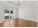 Elegant dining room boasts hardwood floors, a modern chandelier and detailed trim work throughout at 325 Morning Mist Walk, Suwanee, GA 30024