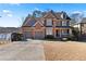 Charming brick home with a two-car garage and a well-manicured lawn, situated near a lake at 325 Morning Mist Walk, Suwanee, GA 30024