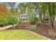 Beautifully landscaped front yard with mature trees and lush greenery leading to a charming home at 4160 Westchester Ne Xing, Roswell, GA 30075