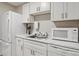 Efficient kitchen features white cabinets, a stainless steel sink, and modern appliances at 5454 Glen Haven Dr, Atlanta, GA 30349