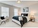 Bright bedroom featuring a bed with decorative pillows, a side chair, and natural light from the windows at 1915 Cassia Aly, Kennesaw, GA 30144