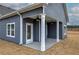 A close up of a covered back porch with a door, white columns, ceiling fans, and gray siding at 201 Daisy Ct, Cartersville, GA 30121