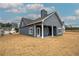 Angled view of the backyard showing a covered porch, windows, siding and a dry, dormant lawn at 201 Daisy Coourt, Cartersville, GA 30121