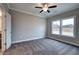 Spacious bedroom featuring plush carpeting, neutral paint, large window, and ceiling fan at 201 Daisy Ct, Cartersville, GA 30121