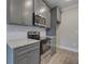 A close up of the gray kitchen cabinets and stainless steel appliances with granite countertops at 201 Daisy Ct, Cartersville, GA 30121