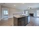 Kitchen island with a sink and stone countertops, and view into the living room at 201 Daisy Coourt, Cartersville, GA 30121