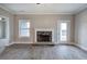 Spacious living room featuring a stone fireplace, bright window, and rear entry door at 201 Daisy Ct, Cartersville, GA 30121