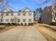 Charming townhome with beige siding and blue shutters, complemented by a spacious driveway and manicured landscaping at 4405 Thorngate Ln, Acworth, GA 30101