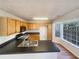 Kitchen with black countertop, wooden cabinets, and bright, sunny windows at 4405 Thorngate Ln, Acworth, GA 30101