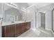 Bathroom featuring dual sinks, dark wood cabinets, a large mirror and tile floor at 1168 Christiana Xing, Lawrenceville, GA 30043