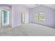 Spacious, purple bedroom boasts carpet and large window at 1168 Christiana Xing, Lawrenceville, GA 30043