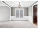 Formal dining room with neutral walls, carpet, modern chandelier, and classic trim work at 1168 Christiana Xing, Lawrenceville, GA 30043