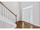 Entryway with hardwood floors, a white front door, and staircase with stained wood railing at 1168 Christiana Xing, Lawrenceville, GA 30043