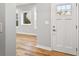 Bright entryway with hardwood floors and a white front door with glass inserts for added natural light at 3185 Tackett Rd, Douglasville, GA 30135