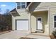 Charming two-story home with a light green exterior, front door, and a neatly attached single-car garage at 3185 Tackett Rd, Douglasville, GA 30135