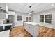 Well-lit kitchen with stainless steel appliances, white cabinets, a center island and hardwood floors at 3185 Tackett Rd, Douglasville, GA 30135