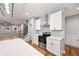 Open concept kitchen featuring white cabinets, stainless steel appliances, hardwood floors and a staircase at 3185 Tackett Rd, Douglasville, GA 30135