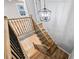 View of staircase with wood treads and black iron railing, complemented by modern lighting fixture at 3185 Tackett Rd, Douglasville, GA 30135