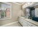 Bright bathroom featuring a granite countertop vanity, large mirror, and natural light from the window at 415 Prestwick Ct, Alpharetta, GA 30005