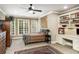 Inviting bedroom with built-in shelving and desk, complemented by natural light from the large windows at 415 Prestwick Ct, Alpharetta, GA 30005