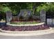 Stone entrance to The Golf Club of Georgia with flowerbeds and wrought iron gates at 415 Prestwick Ct, Alpharetta, GA 30005