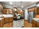 Custom kitchen with stainless steel appliances, wooden cabinets, kitchen island, and a breakfast bar with pendant lights at 415 Prestwick Ct, Alpharetta, GA 30005