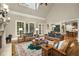 Comfortable living room featuring a vaulted ceiling, large windows and fireplace at 415 Prestwick Ct, Alpharetta, GA 30005