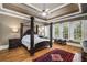 Spacious bedroom featuring tray ceilings, a decorative ceiling fan, hardwood floors, and bright natural light at 415 Prestwick Ct, Alpharetta, GA 30005