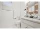 Well-lit bathroom with a granite countertop, modern fixtures, and a decorative wooden mirror at 971 Clover Ln, Lawrenceville, GA 30044