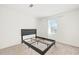 Minimalist bedroom with a black bed frame, neutral carpet, and plenty of natural light at 971 Clover Ln, Lawrenceville, GA 30044