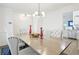 Bright dining room with seating for six, a modern chandelier, and an open view into the kitchen at 971 Clover Ln, Lawrenceville, GA 30044