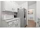 Kitchen featuring white cabinets, subway tile backsplash, granite countertop, and stainless steel appliances at 971 Clover Ln, Lawrenceville, GA 30044