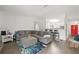 Open-concept living room with modern gray sofa and view into the kitchen and a bright red front door at 971 Clover Ln, Lawrenceville, GA 30044