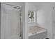 Clean bathroom featuring shower with glass door and soaking tub under a bright window at 1020 Adie Cv, Mcdonough, GA 30253